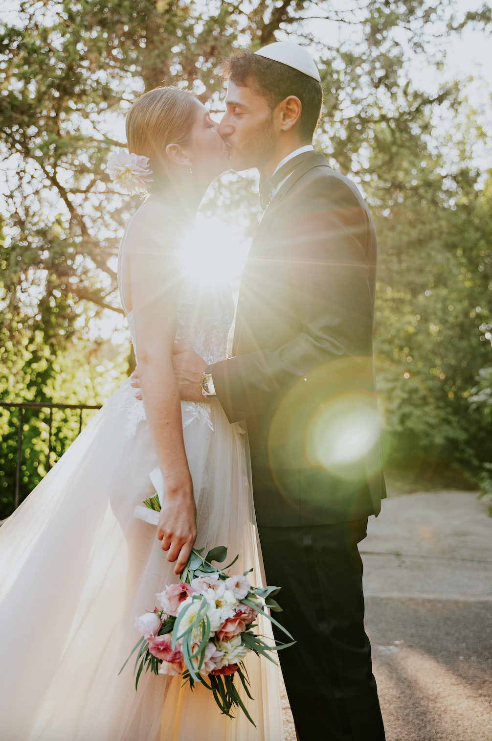 Couple marié qui s'embrassent sous le soleil